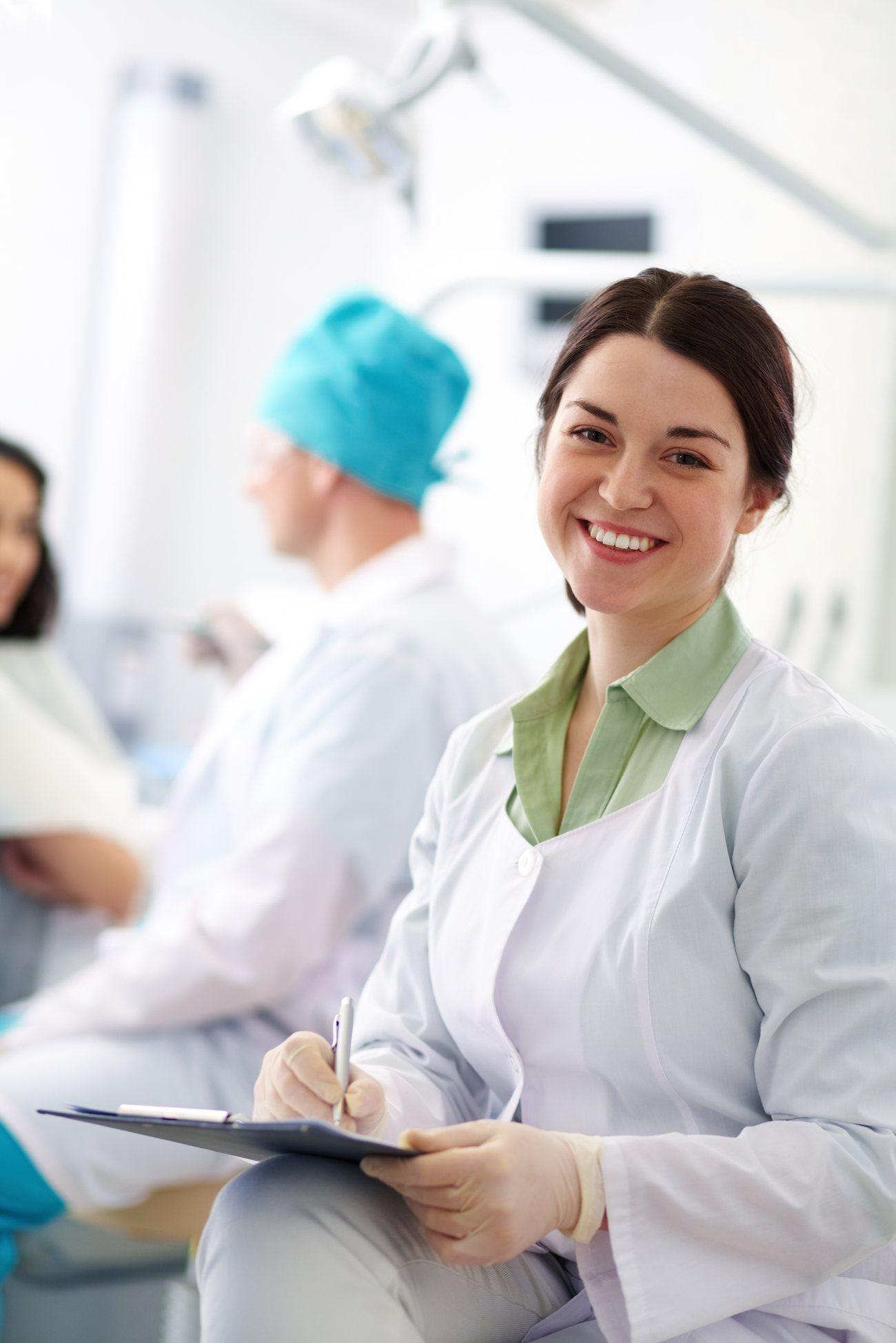 Dentista sorrindo ao lado da equipe em clínica moderna