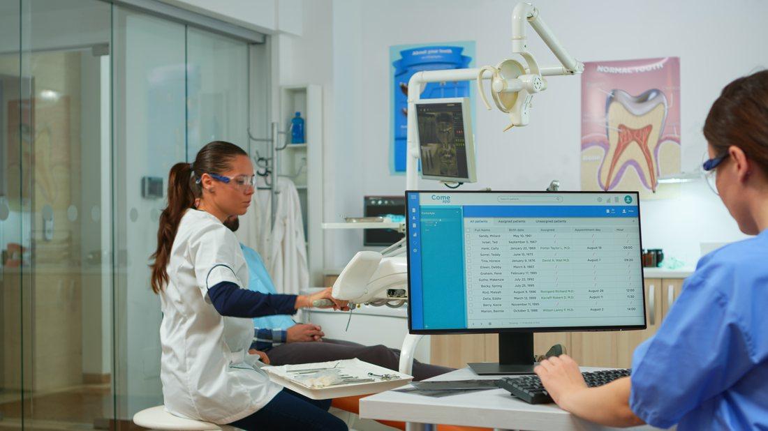 Profissional registrando processos da clínica no computador